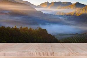 Holztischplatte auf verschwommenem Hintergrund der Teeplantage - kann zur Präsentation Ihrer Produkte verwendet werden foto