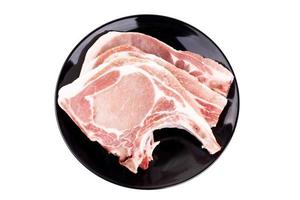 rohes Schweinekotelett auf Teller breit oder Schweinekotelettsteak kochen foto