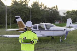 techniker, der den motor des flugzeugs repariert, weibliche luftfahrttechnik, die flugzeugtriebwerke überprüft, asiatische mechanikerwartung inspiziert den flugzeugmotor foto