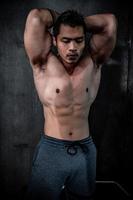 porträt des asiatischen mannes großer muskel im fitnessstudio, thailänder, training für gute gesunde, körpergewichtstraining, fitness im fitnessstudio-konzept foto