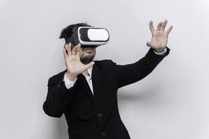 Porträt des jungen Geschäftsmannes trägt eine Virtual-Reality-VR-Brille auf weißem Hintergrund foto