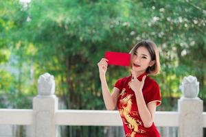 porträt schöne asiatische frau in cheongsam-kleid, thailänder, frohes chinesisches neujahrskonzept, glückliche asiatische dame in chinesischer traditioneller kleidung foto