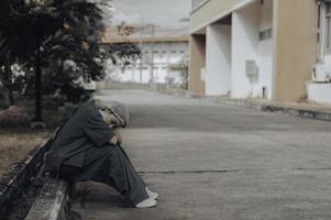 müde depressive asiatische krankenschwester trägt gesichtsmaske blaue uniform sitzt auf dem krankenhausboden, junge ärztin gestresst von harter arbeit foto