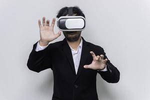 Porträt des jungen Geschäftsmannes trägt eine Virtual-Reality-VR-Brille auf weißem Hintergrund foto
