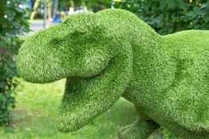 dekorativer dinosaurier aus gras im park foto