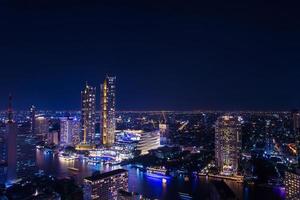 Gebäude im Stadtzentrum entlang des Flusses Chao Phraya, Bangkok bei Nacht, entlang des Flusses gibt es viele Hotels und Hochhäuser für Unternehmen. Bangkok ist das Zentrum für Investitionen. eine der farbenfrohen städte asiens. foto