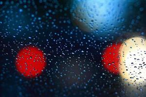 Regentropfen auf Autoglas und buntes Bokeh-Licht foto