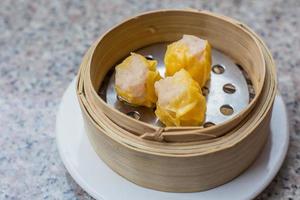 köstliches dim sum oder dumpling ist ein snack aus china und hongkong. shumai oder kanom jeeb oder gedämpftes schweinefleisch und garnelenknödel shumai ist ein gericht der chinesischen küche mit gehacktem schweinefleisch, garnelen. foto