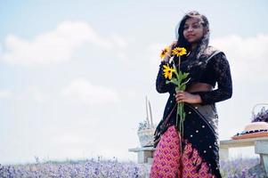 schöne indische Mädchen tragen Saree Indien traditionelles Kleid in lila Lavendelfeld. foto