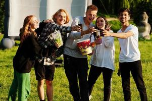 junge multiethnische gruppe von menschen, die filme im poof im open-air-kino ansehen. foto