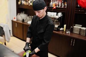 professionelle kochkleidung in schwarz, die sushi und brötchen in einer restaurantküche mit japanischer traditioneller küche herstellt. foto