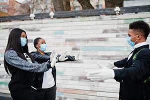 gruppe afrikanischer jugendlicher, die medizinische masken tragen, schützen vor infektionen und krankheiten coronavirus-quarantäne. foto