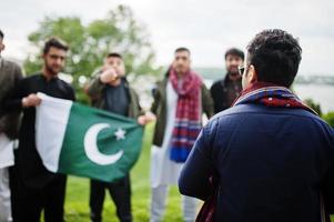 Gruppe pakistanischer Männer, die traditionelle Kleidung Salwar Kameez oder Kurta mit pakistanischen Flaggen tragen. foto