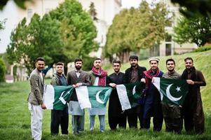 Gruppe pakistanischer Männer, die traditionelle Kleidung Salwar Kameez oder Kurta mit pakistanischen Flaggen tragen. foto