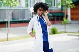 Porträt einer afroamerikanischen Ärztin mit Stethoskop im Laborkittel. foto