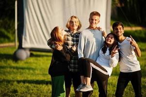 junge multiethnische gruppe von menschen, die filme im poof im open-air-kino ansehen. foto