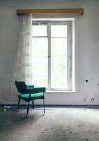 Grüner Stuhl am Fenster foto