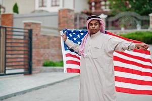 Nahöstlicher arabischer Mann posierte auf der Straße mit usa-Flagge. konzept für amerika und arabische länder. foto