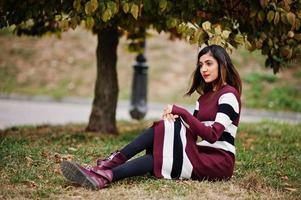 Porträt eines jungen schönen indischen oder südasiatischen Teenager-Mädchens im Kleid, das im Herbstpark posiert. foto