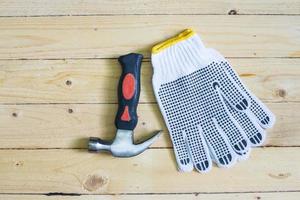 Handschuhe und Hammer auf Holzboden foto