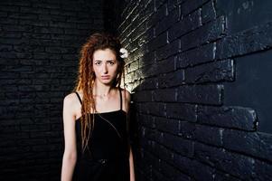 Studio-Shooting von Mädchen in Schwarz mit Dreads auf Backsteinhintergrund. foto