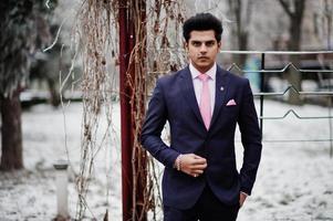 elegantes indisches macho-mann-modell auf anzug und rosa krawatte posierte am wintertag. foto