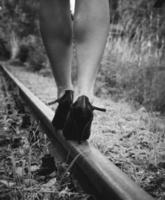 Frau mit High Heels auf einer Bahnstrecke foto