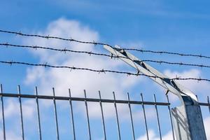 Stacheldraht an einem Tor mit blauem Himmel foto