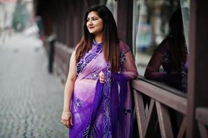 indisches hinduistisches Mädchen im traditionellen violetten Saree posierte auf der Straße. foto