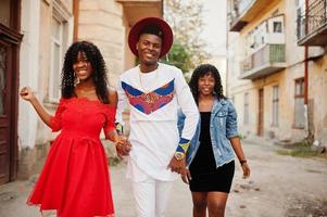 Gruppe von drei stilvollen, trendigen Afro-Frankreich-Freunden posierte am Herbsttag. schwarzafrikanisches Mannmodell mit zwei dunkelhäutigen Frauen. foto