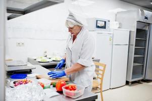 Köchin bereitet Salat in der Küche des italienischen Restaurants zu. foto