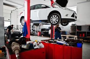 Thema Autoreparatur und -wartung. Mechaniker in Uniform, der im Autoservice arbeitet. foto