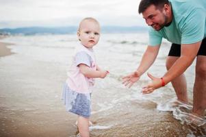 Sommerferien. eltern und menschen outdoor-aktivitäten mit kindern. schöne Familienferien. Vater mit Tochter am Meeressandstrand. foto