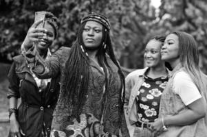 Gruppe von fünf afrikanischen College-Studenten, die gemeinsam Zeit auf dem Campus des Universitätshofs verbringen. schwarze afro-freunde, die selfie am telefon machen. Thema Bildung. foto