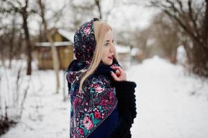 Blondes Mädchen mit handbesticktem Schal posierte am Wintertag. Damen Taschentuch. foto