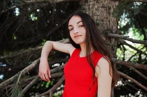 Teenager-Mädchen im roten Kleid posierte im Freien an einem sonnigen Tag. foto