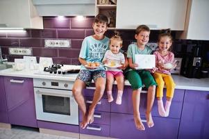 Kinder kochen in der Küche, glückliche Kindermomente. vier Kinder, große Familie. foto