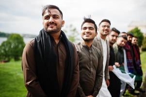 Gruppe pakistanischer Männer, die traditionelle Kleidung Salwar Kameez oder Kurta mit pakistanischen Flaggen tragen. foto