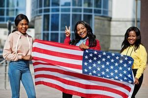 drei junge afroamerikanische College-Freundinnen mit US-Flagge. foto