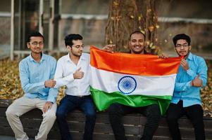 Gruppe von vier südasiatischen indischen Männchen mit Indien-Flagge. foto