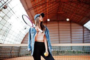 junge sportliche Spielerin mit Tennisschläger auf dem Tennisplatz. foto