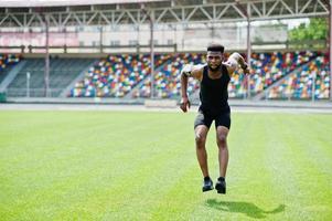 afroamerikanischer männlicher athlet in sportbekleidung, der im stadion sprungübungen macht. foto