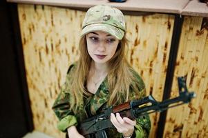 Mädchen mit Maschinengewehr an den Händen auf dem Schießstand.