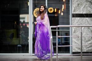 indisches hinduistisches Mädchen im traditionellen violetten Saree posierte auf der Straße. foto