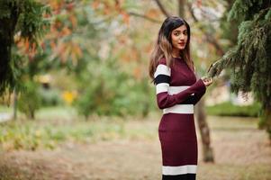 porträt eines jungen schönen indischen oder südasiatischen teenager-mädchens im kleid, das im herbstpark in europa posiert. foto