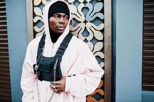 stilvoller afroamerikanischer mann im urbanen stil in rosa hoodie posiert. Afro-Rapper-Typ. foto