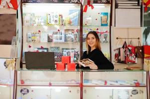 Porträt einer jungen kaukasischen Verkäuferin mit handgemachten Keksen und Süßigkeiten. kleines Geschäft mit Süßigkeiten-Souvenir-Shop. foto