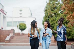 Gruppe junger schwarzer Freundinnen, die in der Stadt herumhängen. gemischtrassige afrikanische frauen, die durch die straße gehen und diskutieren. foto