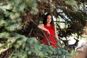 Teenager-Mädchen im roten Kleid posierte im Freien an einem sonnigen Tag. foto