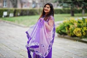 indisches hinduistisches Mädchen im traditionellen violetten Saree posierte auf der Herbststraße. foto